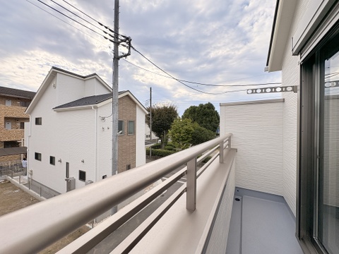 手すり付きのバルコニーから周辺の住宅を望む