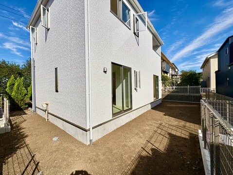 白い外壁の住宅と砂利敷きの外周スペース