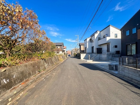 住宅が並ぶ前面道路と周辺の街並み
