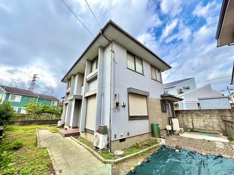 白壁の戸建て外観と前面の庭