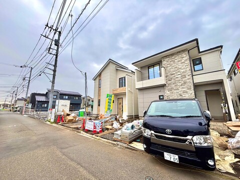 道路沿いに建つ2階建て住宅と駐車スペース