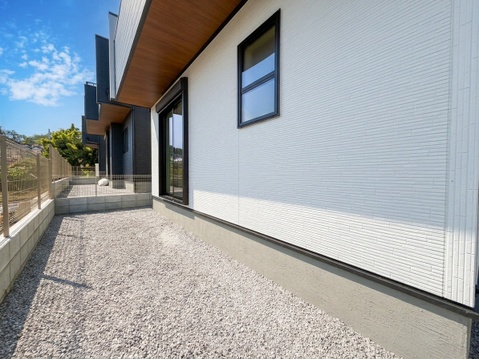 建物脇の砂利敷き通路と外壁