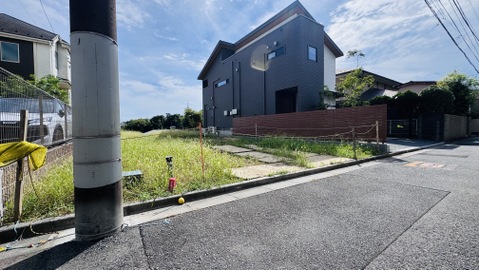 道路沿いの角地に面した住宅と広い空地