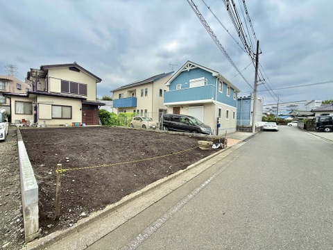 前面道路と隣接する更地、住宅街の街並み