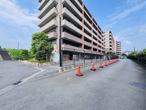 多層構造のマンション外観と周囲道路の様子