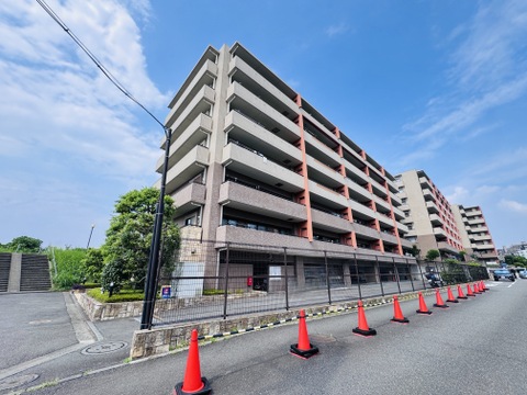 複数階の集合住宅の外観、広い敷地と通路が見える
