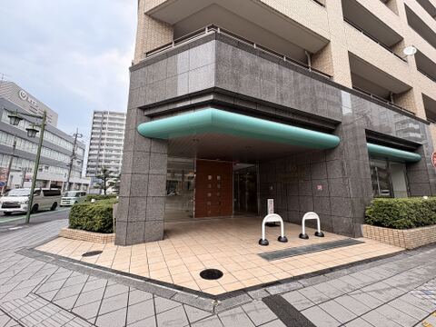 マンションのエントランス外観と周辺の歩道が見える様子