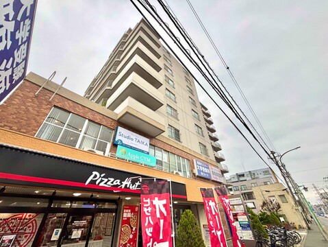 周辺に飲食店がある高層マンションの外観写真です