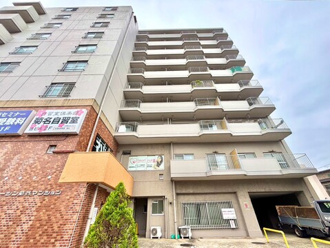 複数階建てのマンション外観、周辺に商業施設あり