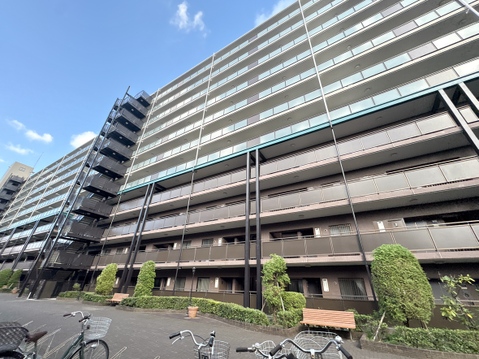複数階建ての集合住宅の外観と駐輪スペースを撮影
