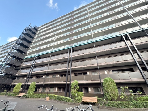 多層階のマンション外観、周囲に自転車置き場あり