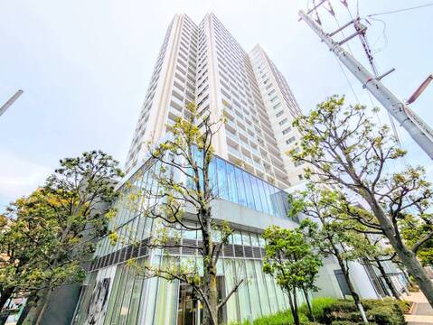 高層ビルの外観、周囲に木々がある立地です