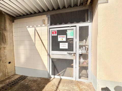 共用部の自動ドアと掲示板が見えるエントランス付近の様子