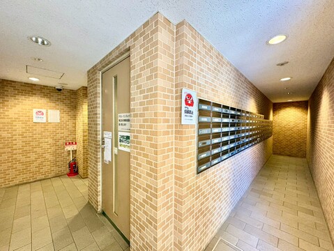 集合郵便受けと通路があるマンション共用部の様子です