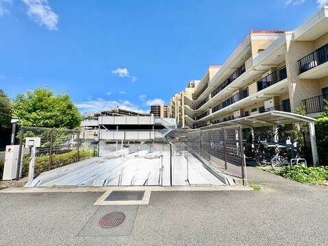 スロープ付きの駐車場がある集合住宅の外観です
