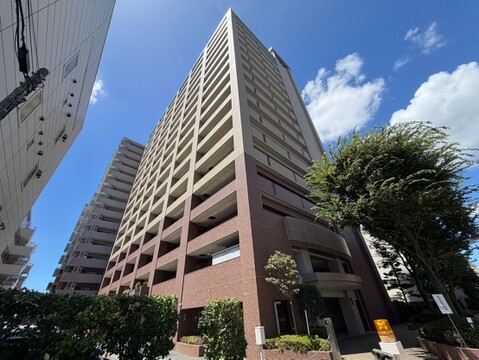 周辺に緑がある高層マンションの外観写真です