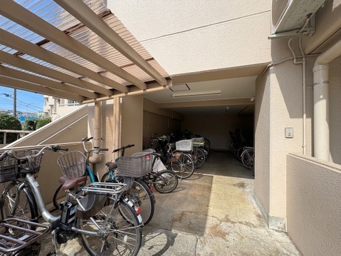 屋根付きの駐輪場と車庫スペースがある物件外観