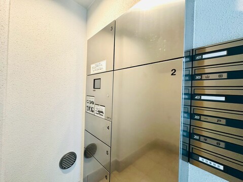 集合ポストとメールボックスのあるマンションのエントランス