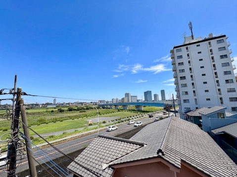 建物屋上から見た住宅街と遠景のビル群の眺望