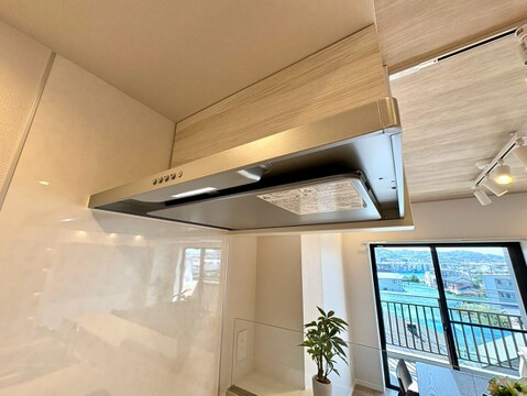 キッチンの換気扇と窓からの眺望が見える室内の様子