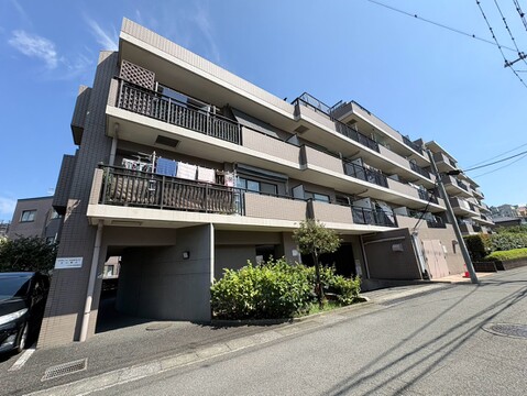 複数階建ての集合住宅外観、周辺に道路あり