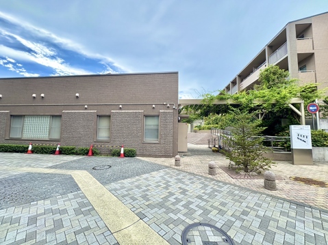 建物前の広い駐車スペースと周辺の緑地