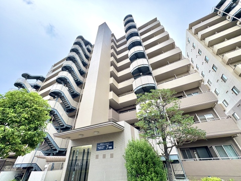 高層マンションの外観周囲に緑が見える環境