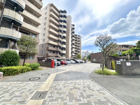 マンションの外観と敷地内の駐車場の様子