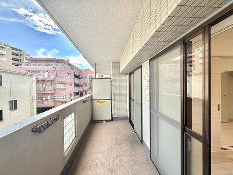 広いバルコニーとマンション街の眺望が見える窓