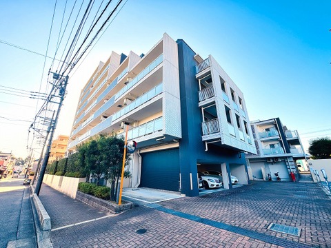 複数階の大型マンション外観、周辺に電柱と歩道あり