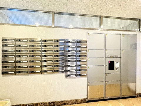 集合ポストと宅配ボックスがあるマンションのエントランス