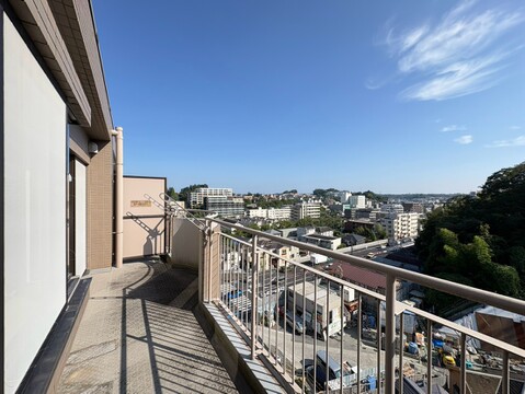 広々としたバルコニーと遠くに見える住宅街の眺望