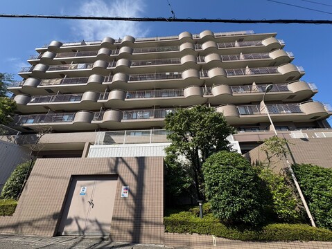 複数階建ての住宅マンションの外観周囲に緑もある