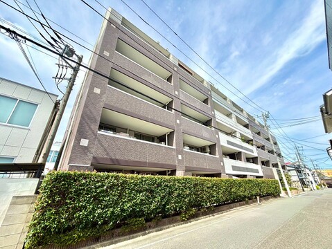 白い外壁とバルコニーが特徴のマンション外観
