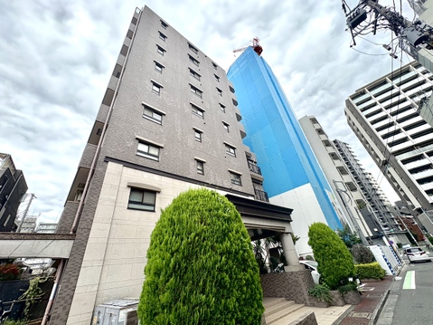 複数階建の高層マンションの外観と周辺ビルの様子