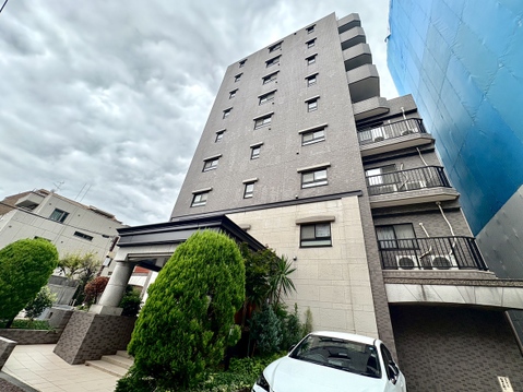 多階建てのマンション外観と植栽が見える風景