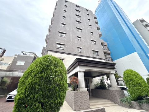 敷地内に植栽があるマンションの外観です