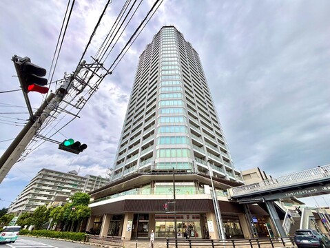 高層のタワーマンション外観、周辺に歩道と建物あり