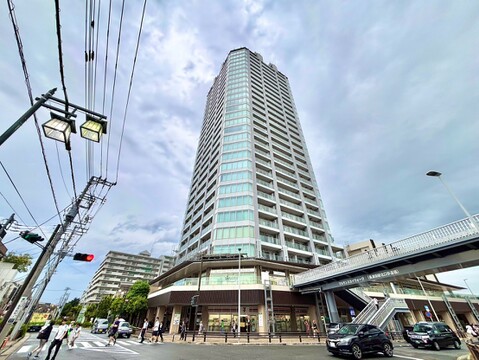 高層のマンション外観周辺に道路と歩道橋が見える