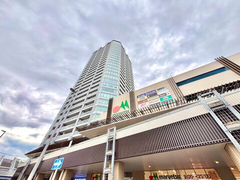 高層マンションの外観と隣接する商業施設の様子