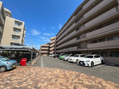 建物横の駐車場スペースと周辺の住宅