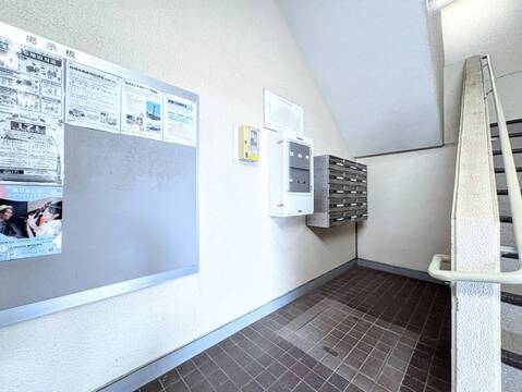 掲示板と階段があるマンションの共用エントランス