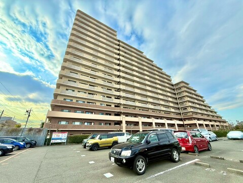 広い駐車スペースがあるマンションの外観