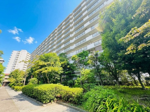 緑豊かな植栽がある高層マンションの外観です