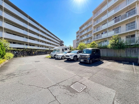 建物間の駐車スペースと周辺の住宅棟を望む風景です