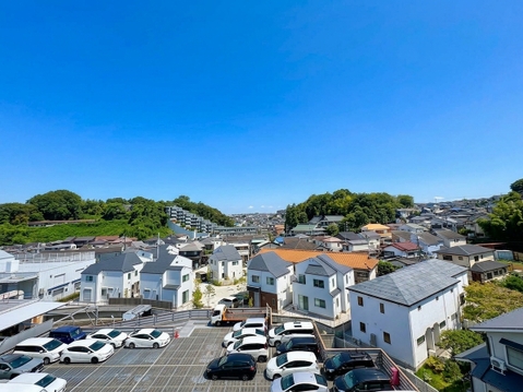 住宅街と駐車場が見える晴天の眺望です