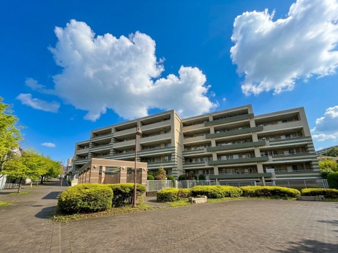 青空の下に建つ集合住宅の外観