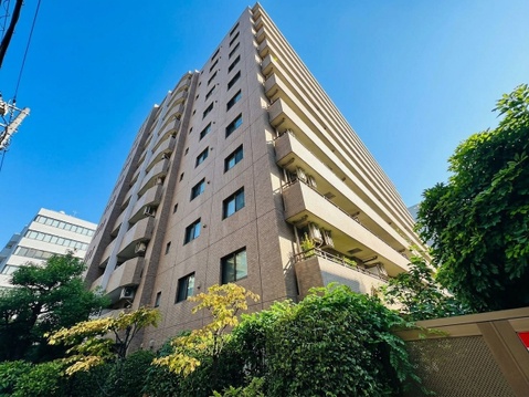 植栽に囲まれた高層マンションの外観