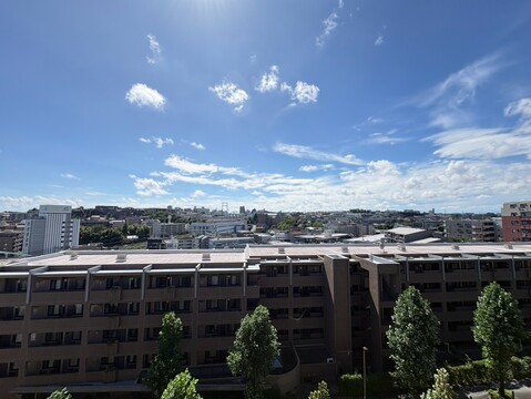 建物越しに市街地と山並みを望む眺望
