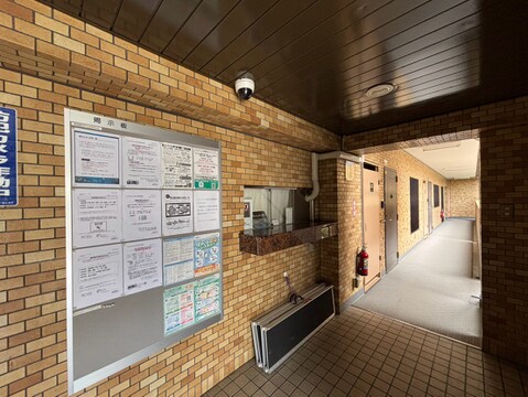 レンガ調の壁に囲まれた建物の共用通路